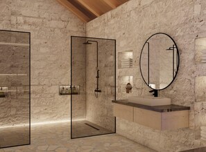 Un baño moderno con pared de piedra, ducha envuelta en vidrio, tocador de madera y un espejo grande.