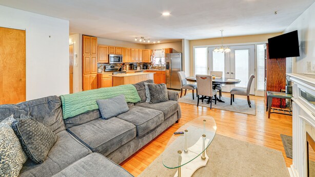 A modern living room with a gray sofa, a glass coffee table, and a dining area with a table and chairs. - 4 Mi to Dtwn: Pet-Friendly Home in Utica (Utica)
