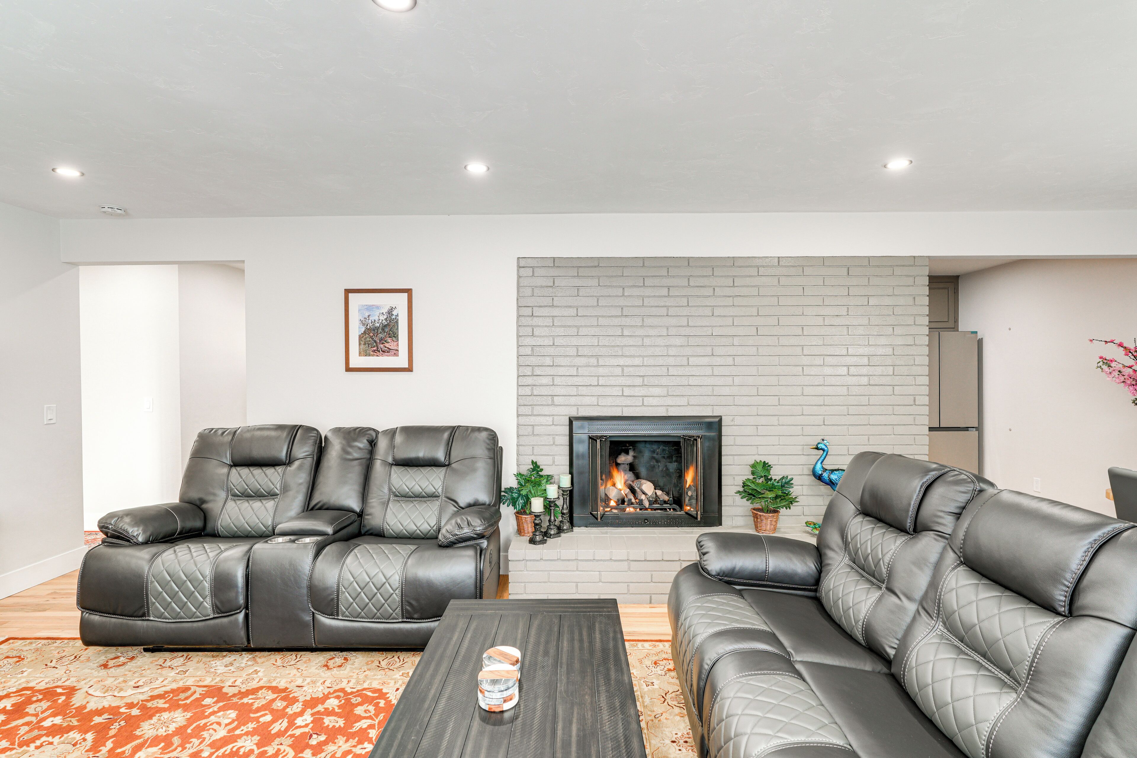A living room with a fireplace, leather sofas, and a coffee table.