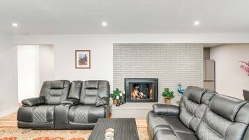 A living room with a fireplace, leather sofas, and a coffee table.
