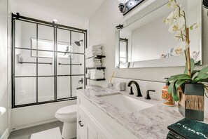 A modern bathroom with a glass-enclosed shower, a white sink with a marble countertop, and a large mirror above the sink. - 2 Mi to Beach: Home w/ Patio in Del Rey Oaks! (Del Rey Oaks)