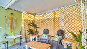 A cozy outdoor seating area with a wooden table and chairs, a small round table, and a patterned rug. - Stylish St Pete Studio: Full Kitchen & Laundry (St. Petersburg)
