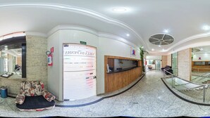 Zona de recepción con mostrador, extintor, área de estar y máquina expendedora.