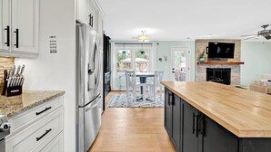 Una cocina moderna con una isla central, electrodomésticos de acero inoxidable y una zona de comedor con vistas.