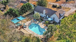 Una casa grande con piscina, patio y terraza.