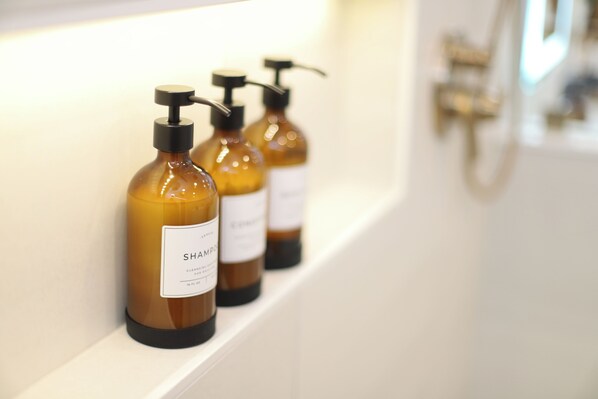 Three bottles of shampoo on a white shelf in a bathroom. - Romantic, Luxurious Getaway in the Heart of Amish Country (Sugarcreek)