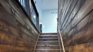 Una escalera de madera con barandilla que sube.