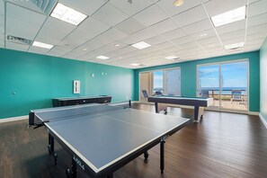 Una stanza con un tavolo da ping pong, un tavolo da biliardo e un'ampia finestra vista panoramica.