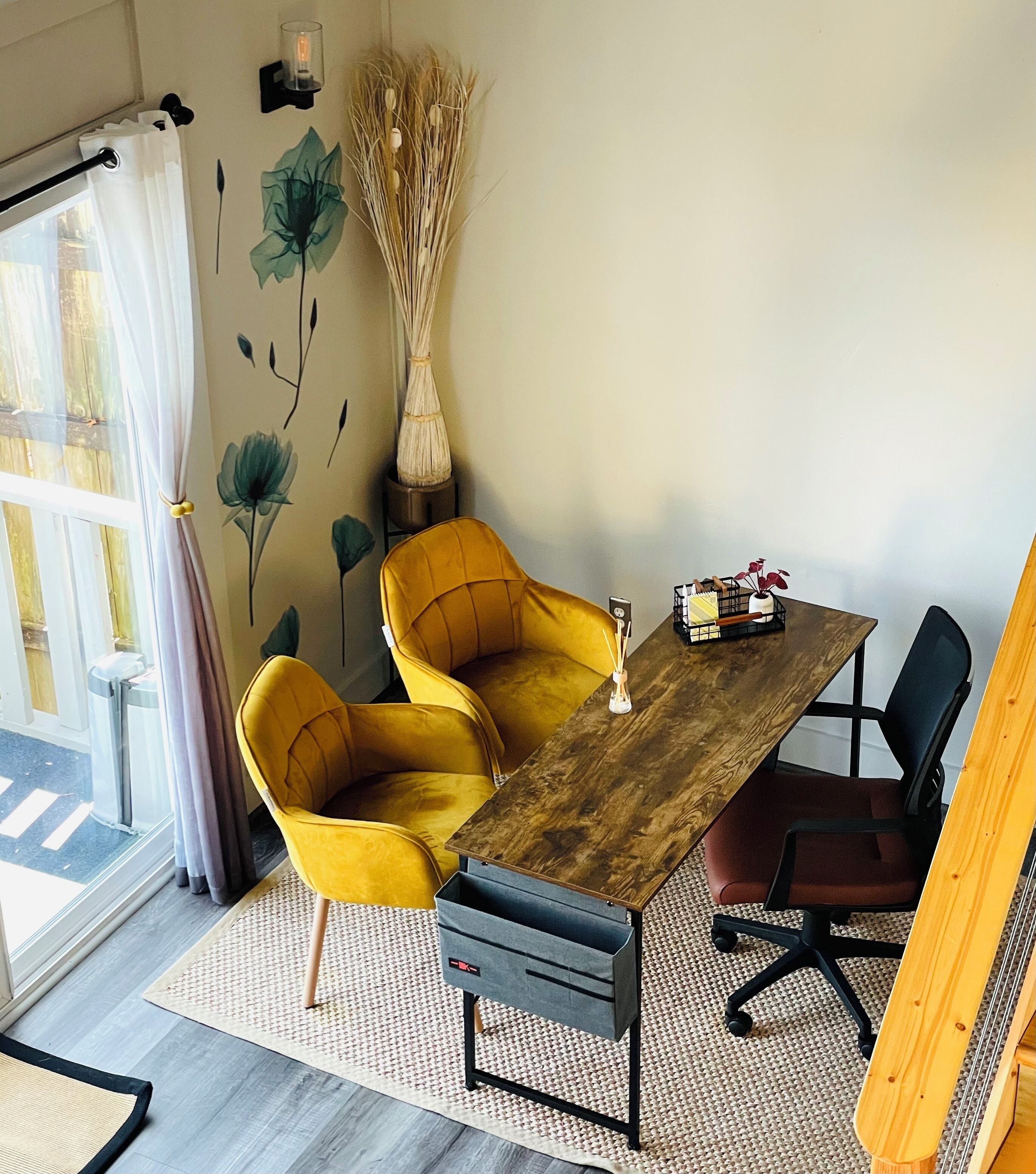 A dining area with a wooden table, yellow chairs, and a black office chair.