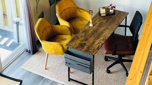 Ein Essbereich mit einem Holztisch, gelben Stühlen und einem schwarzen Bürostuhl.