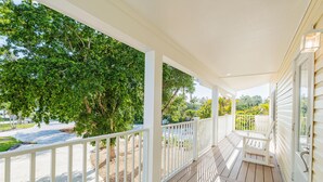 A covered porch with white railings, a wooden deck, and a welcome mat. - Great Escape-5 (Fort Myers Beach)