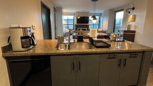 Una cocina moderna con encimeras de granito, electrodomésticos de acero inoxidable y una isla central.