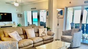Una sala moderna con un sofá de cuero, una mesa de centro de vidrio y una silla.