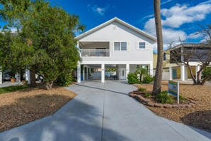 A two-story building with a covered front porch and a balcony. - Dolphin Dream (Fort Myers Beach)
