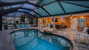 A swimming pool with lounge chairs and a covered patio area. - The Lazy Place (Fort Myers Beach)