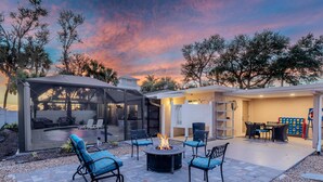 A patio area with outdoor seating, a fire pit, and a covered seating area. - Happy Daze (Fort Myers Beach)