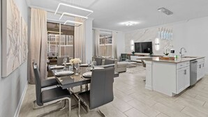 A modern kitchen with white cabinets, a central island, and a built-in oven. - Special 4bedroom TH w Private Pool Next to Disney (Davenport)