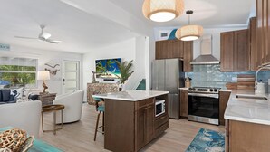 Una cocina moderna con armarios de madera, electrodomésticos de acero inoxidable y una isla central.