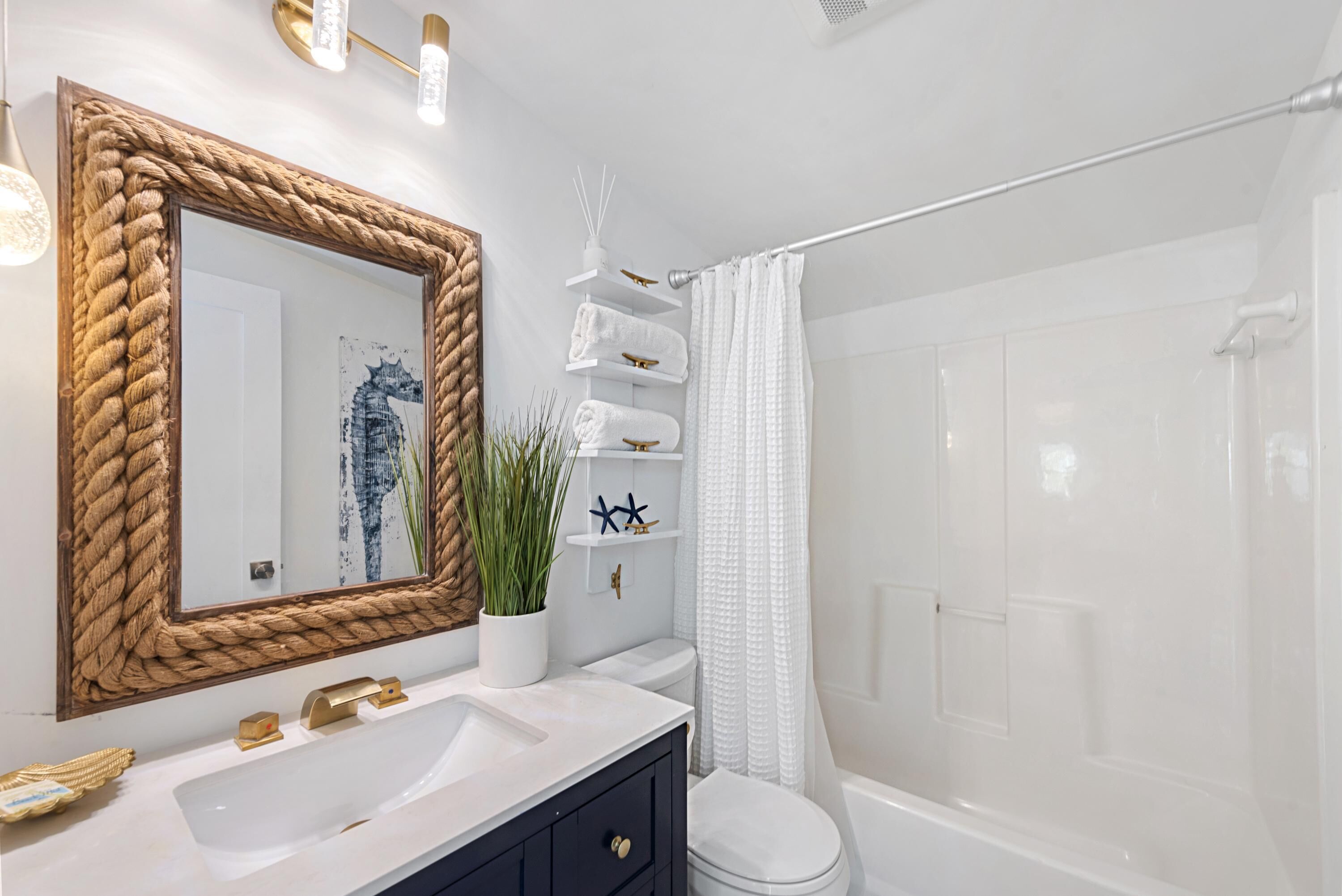 A bathroom with a large mirror, white sink, and a shower area.