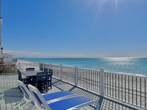 A deck with lounge chairs and a table overlooking a beach. - Ultimate coastal retreat! (Panama City)