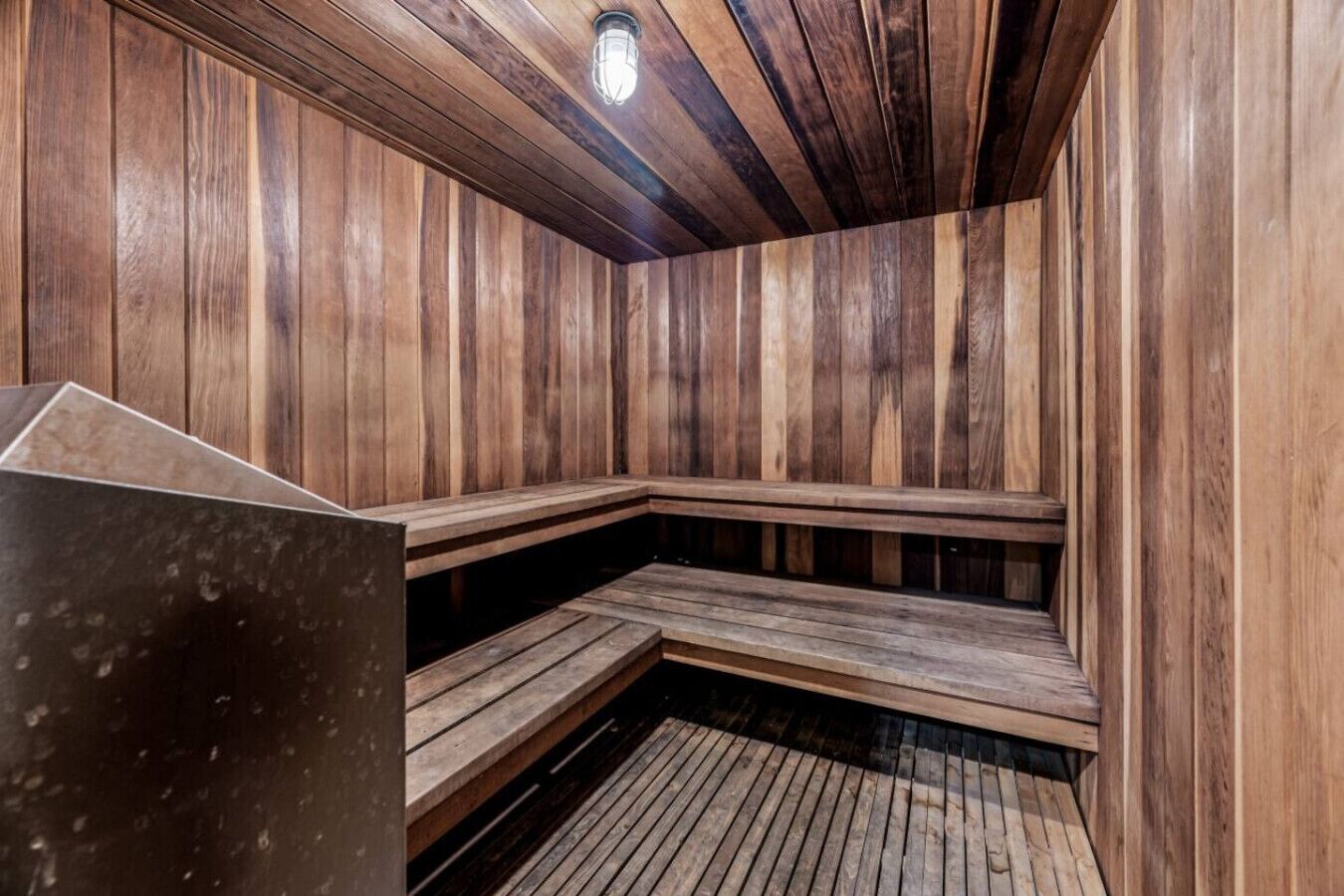 A sauna with wooden benches and a sloped ceiling.