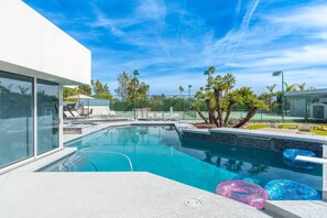 A modern outdoor swimming pool with clear blue water, surrounded by lounge chairs and palm trees. - Desert Diamond HTD Pool/Hot Tub/Tennis/BBall/Sauna (Scottsdale)