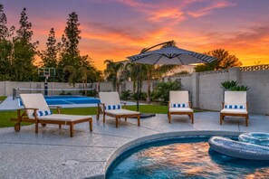 A pool area with lounge chairs, a basketball hoop, and a sunset view. - Active Cactus - Pickleball/Bball, HTD Pool, Golf (Scottsdale)
