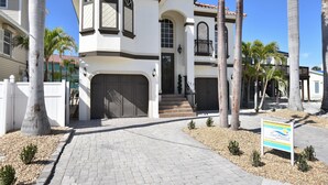 Ein zweistöckiges Haus mit Balkon, Garage und Auffahrt.