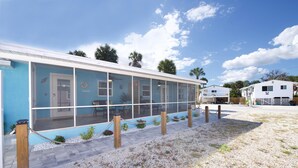 Fileira de quartos de motel azuis e brancos, com janelas amplas e área externa coberta.