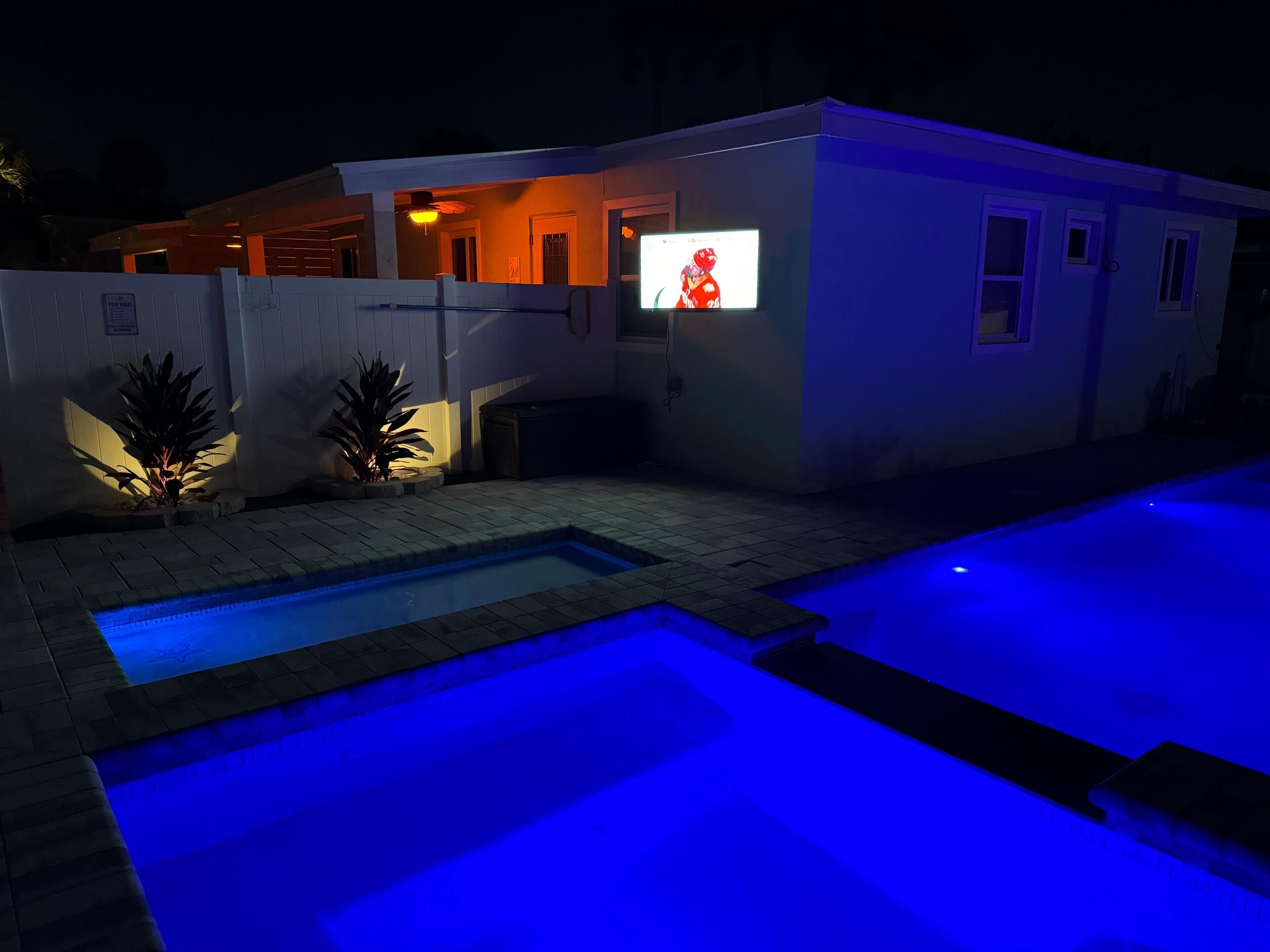 A modern house with a swimming pool, a TV mounted on the exterior wall, and a sign indicating a 'No Parking' zone.