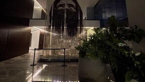 A modern interior with a central sculpture, a potted plant, and a marble floor. - Luxury 3BR Condo in Colonia Americana Pool, Gym & Workspace (Ladron de Guevara)