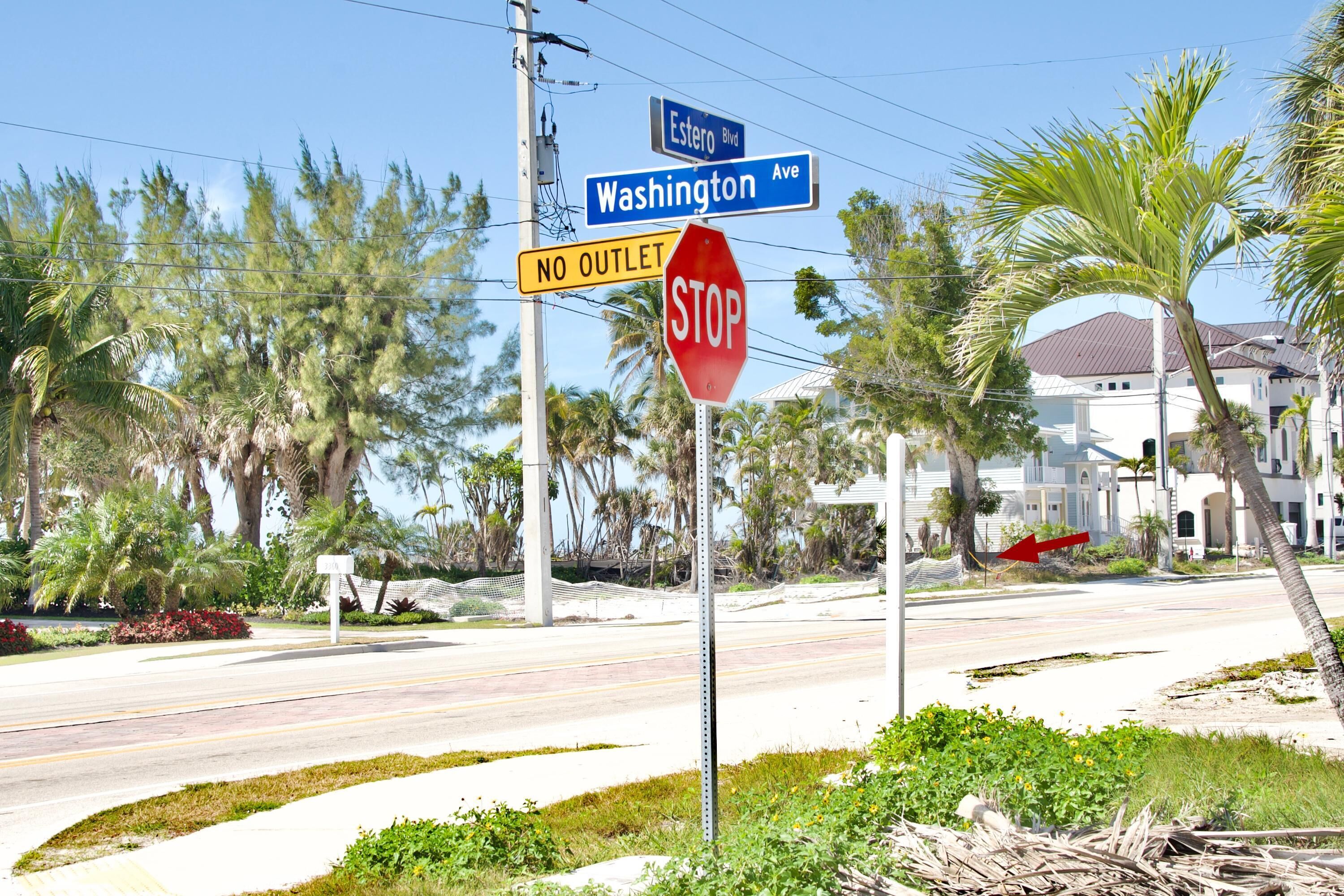 A street corner with a stop sign, street signs for 'Esterro Blvd' and 'Washington Ave', and a 'NO OUTLET' sign.