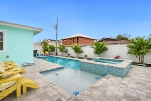 Relax by the pool surrounded by a starfish-patterned deck and lounge chairs.
