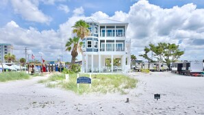 A beachfront house with a two-story structure, a covered porch, and a sign indicating it is for sale. - White Sugar Sands (Fort Myers Beach)
