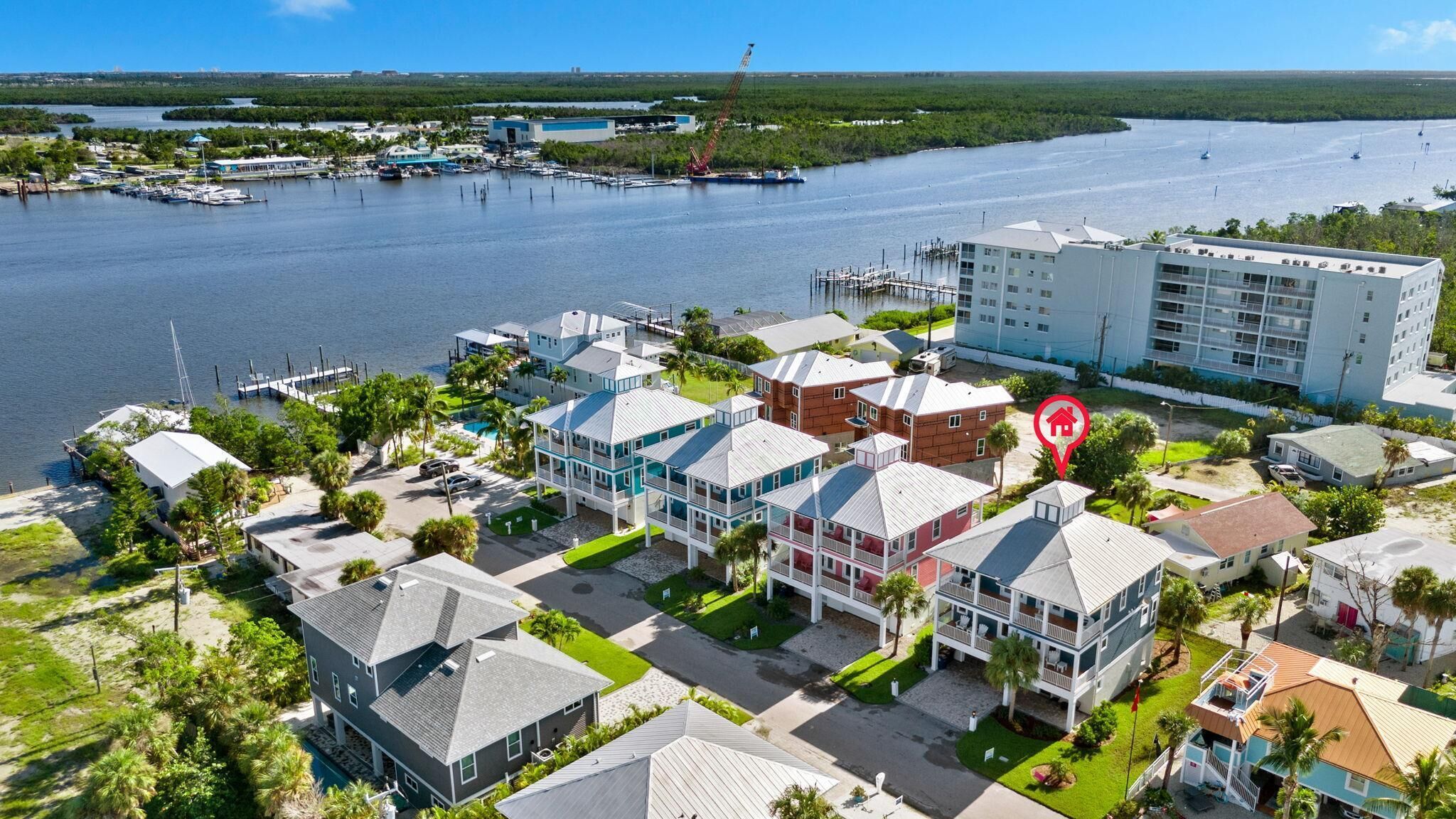 A coastal residential area with houses, a marina, and a large building with balconies.