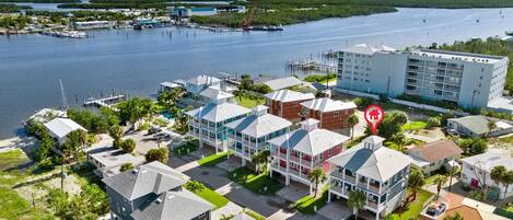 A coastal residential area with houses, a marina, and a large building with balconies.