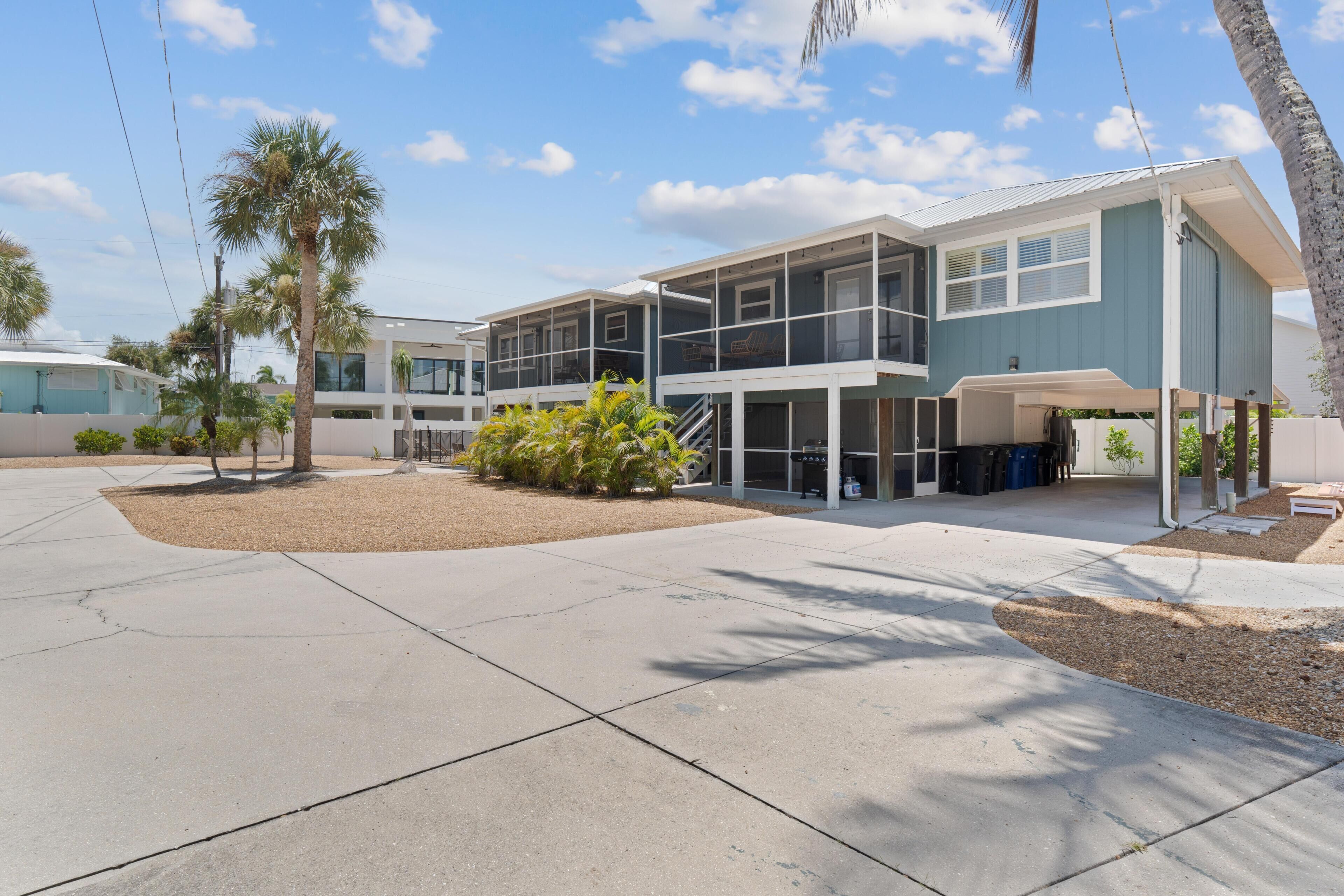 A modern two-story building with a covered patio area and a landscaped courtyard.