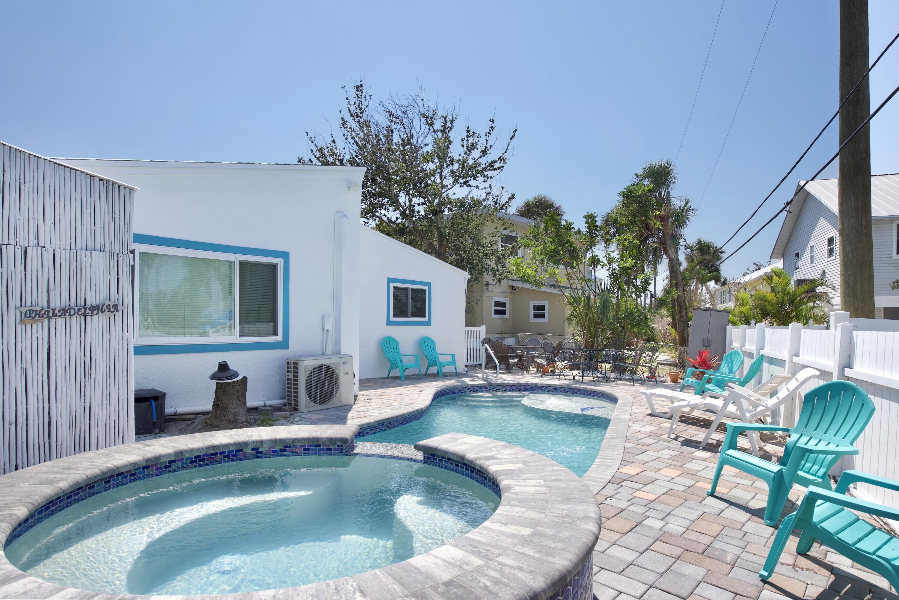 Un jardin avec deux bains à remous, un espace patio et du mobilier d’extérieur.