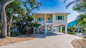 A two-story house with a balcony and a covered porch. - Island Breeze (Fort Myers Beach)