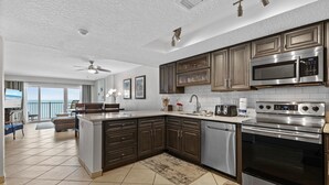 Una cocina moderna con electrodomésticos de acero inoxidable, armarios de madera oscura y una isla grande.