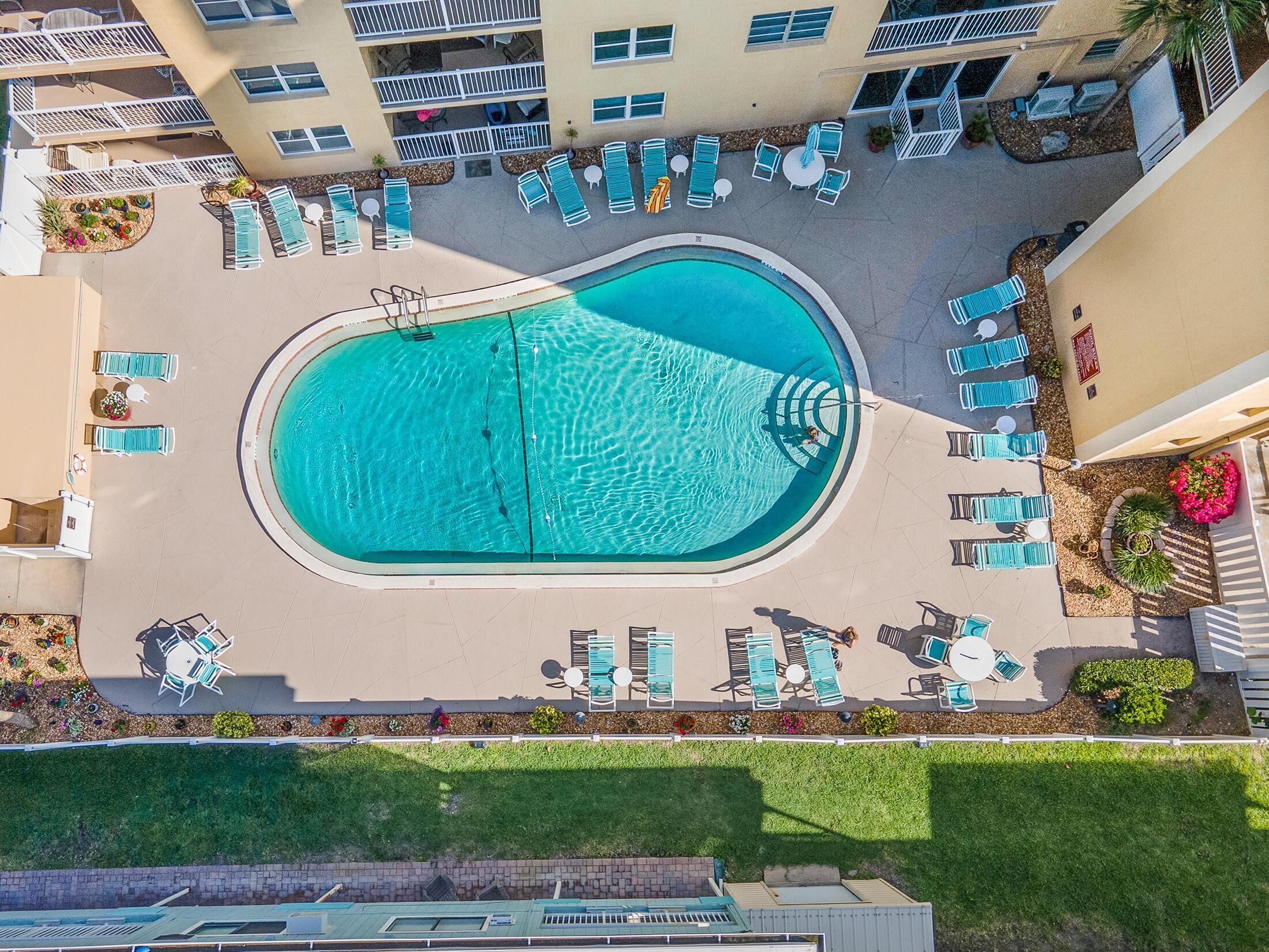 A rooftop pool with multiple lounge chairs and a central diving area.