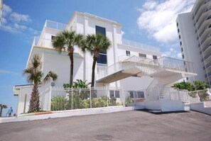 A modern white building with a balcony and palm trees. - Smyrna Beach Club 607a (New Smyrna Beach)