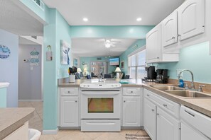 Enjoy cooking in this well-equipped kitchen with a central island, double sink, and ample counter space.