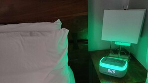 A bed with white bedding, a bedside table with a digital clock displaying 9:29, and a green ambient light. - beautiful, cozy private and quiet house + heat garage -EV charger - NO BASEMENT (Edmonton)