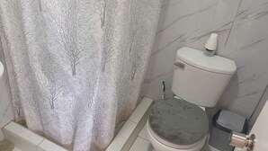 Een badkamer met toilet, wastafel en douchegordijn.