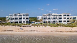 A beachfront hotel with multiple floors, a pool, and a beach area.