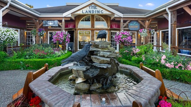 A building with a sign reading "THE LANDING" and a garden with a rock fountain.