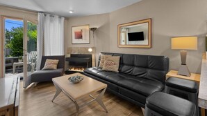A modern living room with a leather sofa, a wooden coffee table, and a fireplace.