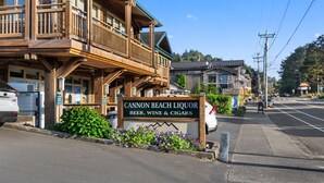 Un edificio de madera con un letrero que dice "Cannon Beach Liquor" y un balcón.