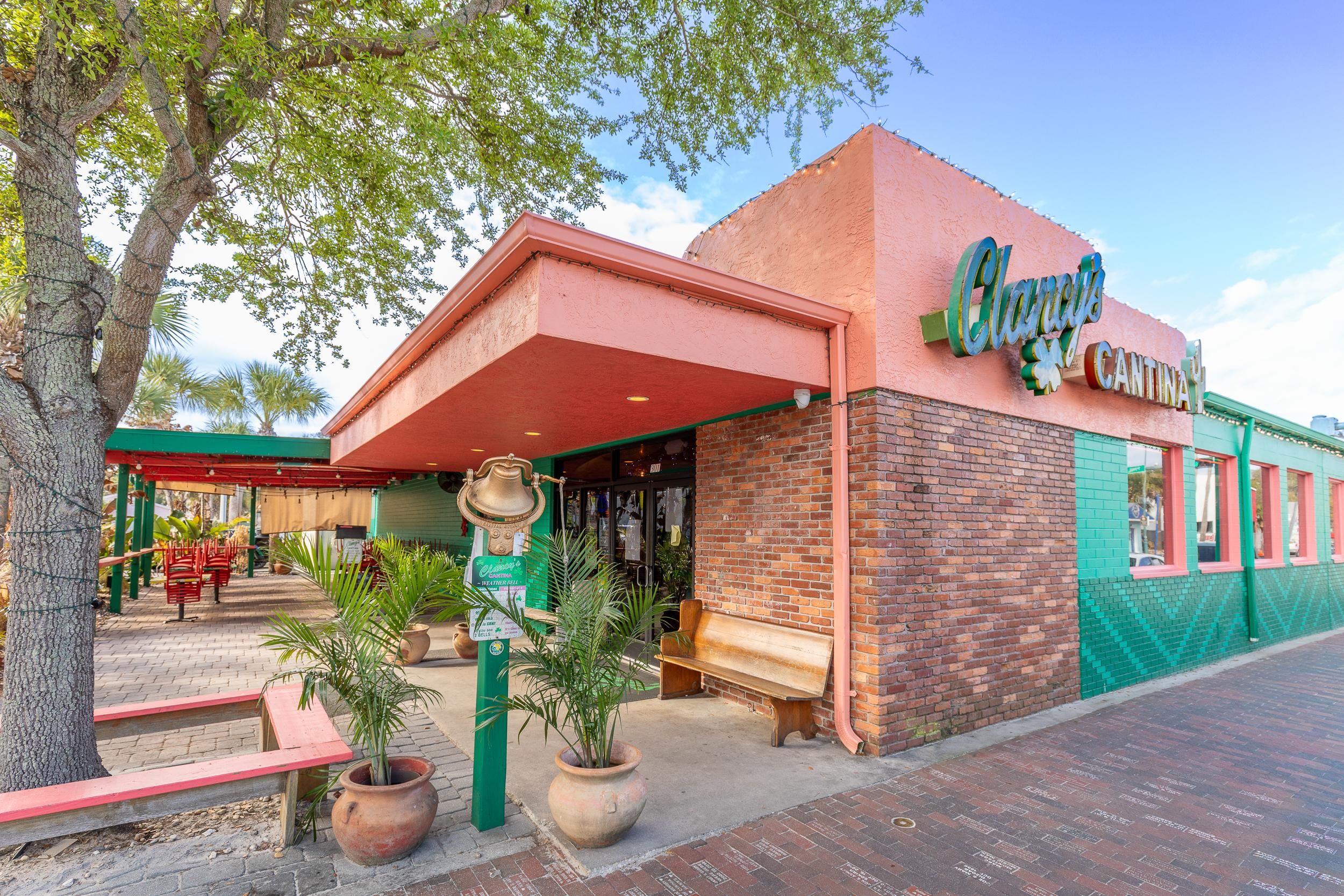 Un edificio con un cartello che riporta 'Clancy's Cantina' e una struttura a forma di campana di fronte.
